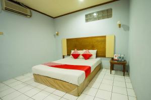 a bedroom with a large bed with red pillows at Hotel O Mega Sentosa in Samarinda
