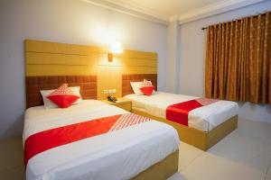 a hotel room with two beds and a window at Hotel O Mega Sentosa in Samarinda +27 photos