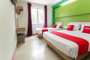 a bedroom with two beds with red and green walls at Valley View Hotel in Lumut