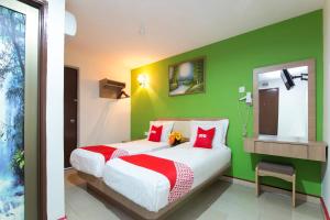 a bedroom with two beds and a green wall at Valley View Hotel in Lumut