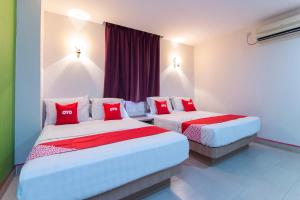 two beds in a hotel room with red pillows at Valley View Hotel in Lumut +43 photos