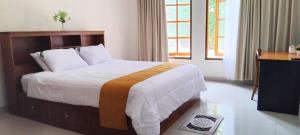 a bedroom with a bed and a desk and a television at Amini Guest House in Jatiayu