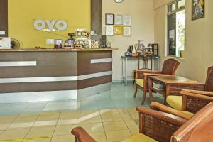 a restaurant with a counter and chairs in a room at Hotel O De Perdana Hill in Batu Pahat
