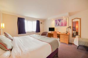 a hotel room with a large bed and a desk at OYO Lakeside Haydock Hotel, St Helens, A580 East Lancs, Garswood Old Road in Saint Helens
