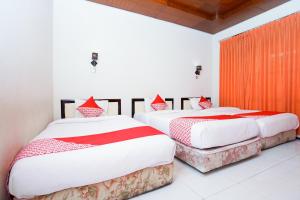 Postel nebo postele na pokoji v ubytování Capital O 1430 Hotel Ratna Syariah