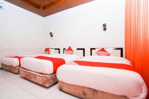 Postel nebo postele na pokoji v ubytování Capital O 1430 Hotel Ratna Syariah