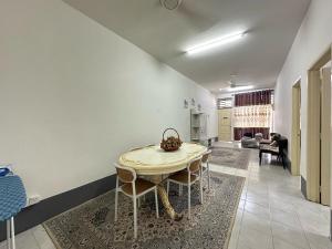 a dining room with a table and chairs in a room at Rumah Melur - 10km dari Matrik Kelantan in Pasir Puteh