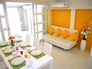 ein Wohnzimmer mit einem Tisch und einem Sofa in der Unterkunft Kata Plaza 1 bedroom Modern Apartment in Kata Beach