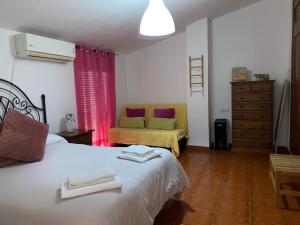 a bedroom with a white bed and a couch at Casa Cris in Aracena