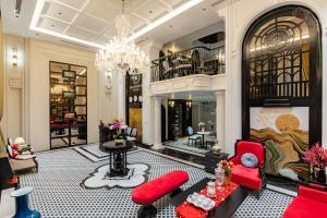 a living room with red furniture and a chandelier at Ella Riverside Hotel in Lao Cai