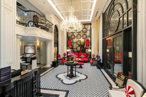 a hotel lobby with a chandelier and a table at Ella Riverside Hotel in Lao Cai