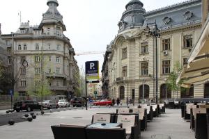 una strada con tavoli e sedie di fronte agli edifici di Studio Old Town a Bucarest