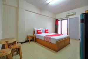 曼谷Ok Home Airport的一间卧室，床上有红色枕头