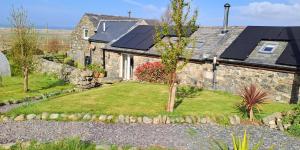 达夫林Bryn Teg Barn的屋顶上设有太阳能电池板的石头房子