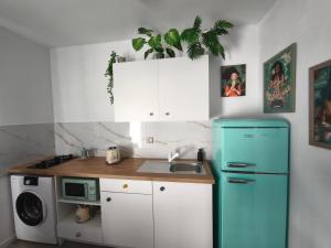 a kitchen with a blue refrigerator and a microwave at Home Glos ter in Tarajalejo