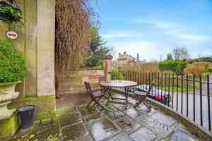 a table and chairs in front of a fence at OYO Bailbrook Lodge, Bath in Bath