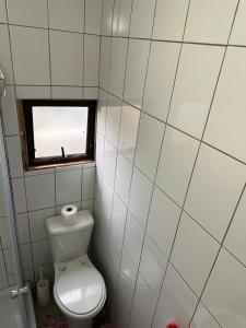 a small bathroom with a toilet and a window at Dream View Mountain Cabin 2 in Durban