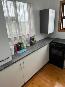 a kitchen with white cabinets and a counter top at Dream View Mountain Cabin 2 in Durban +17 photos