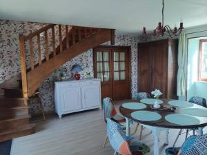 a living room with a table and chairs and a staircase at Gîte Charolais Burgundy in Mont-et-Marré