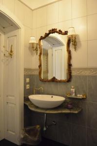 La salle de bains est pourvue d'un lavabo blanc et d'un miroir. dans l'établissement Gabi B&B, à Vilnius