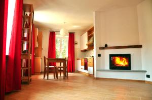 a living room with a fireplace and red curtains at Tana Degli Orsi in Cantalupo Ligure