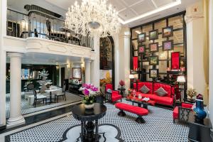a lobby with red furniture and a chandelier at Ella Riverside Hotel in Lao Cai