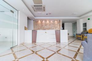a living room with a tile floor and a brick wall at Super OYO 106 Muscat Grand Hotel Apartment in Seeb