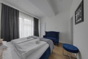a bedroom with a bed and a blue chair at Shone apartment old town 2 bedroom in Bratislava