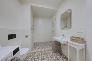 a white bathroom with a sink and a mirror at Shone apartment old town 2 bedroom in Bratislava +34 photos