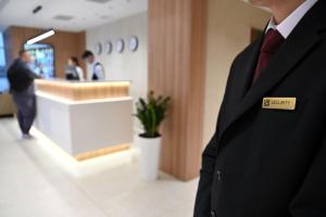 a man in a suit with a sign on his tie at Resident Hotel Abay in Almaty
