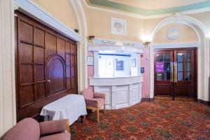 a room with a fireplace and a table and chairs at George Hotel, Burslem, Stoke-on-Trent in Stoke on Trent