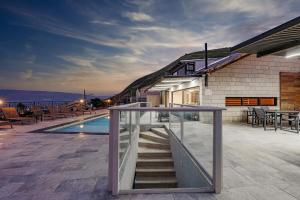 提比里亚וילה רז של רשת לב הגולן - וילה מדהימה עם בריכה פרטית מחוממת וסאונה的一座房子,设有楼梯,毗邻游泳池