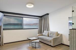 提比里亚וילה רז של רשת לב הגולן - וילה מדהימה עם בריכה פרטית מחוממת וסאונה的客厅配有椅子和大窗户