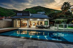 提比里亚וילה רז של רשת לב הגולן - וילה מדהימה עם בריכה פרטית מחוממת וסאונה的一栋房子前面有游泳池 更多22张照片