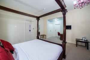 a bedroom with a canopy bed and a room with a table at George Hotel, Burslem, Stoke-on-Trent in Stoke on Trent +24 photos
