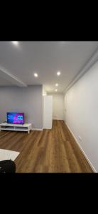 a living room with a tv and a wooden floor at an der Elbe in Freiburg - Elbe
