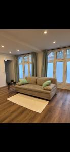 a large couch in a living room with windows at an der Elbe in Freiburg - Elbe