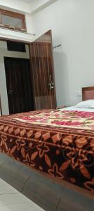 AyodhyaにあるJanki Paying Guest Houseの木製のドアが備わるドミトリールームのベッド1台分です。