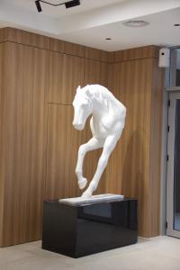a statue of a white horse on a stand in a room at Resident Hotel Abay in Almaty +90 photos