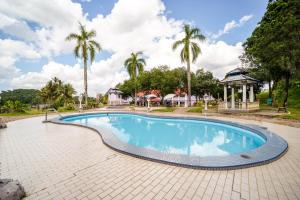 a swimming pool with a gazebo and palm trees at Hotel O Kulim Inn in Kulim