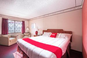 a bedroom with a large bed with a red blanket at OYO Hotel Windmill Branson in Branson