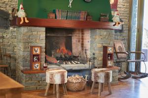 a living room with a fireplace with two stools at GRAN CHALET HOTEL & PETiT SPA WELLNESS in Vielha