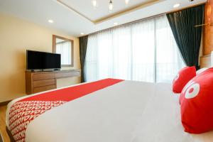 une chambre avec un grand lit avec des oreillers rouges et une télévision dans l'établissement OYO 458 Nakorn Siam Boutique, à Pattaya 17 autres photos