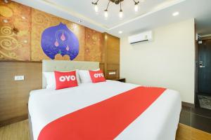 une chambre avec un grand lit avec des oreillers rouges et blancs dans l'établissement OYO 458 Nakorn Siam Boutique, à Pattaya