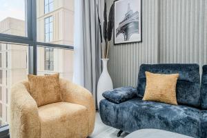 a living room with a chair and a chair and a vase at 1BR Poolview Apartment by Blue Cloud Holidays in Sharjah Intl +20 photos