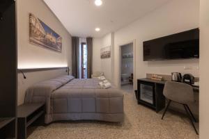 a bedroom with a bed and a desk and a television at auntieshouseroma in Rome