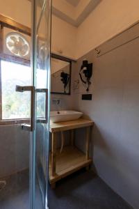 a bathroom with a tub and a sink and a mirror at Eden Stay & Cafe in Jibhi