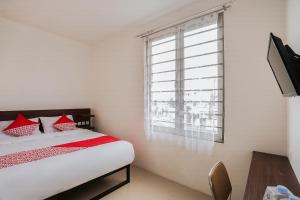 Postel nebo postele na pokoji v ubytování Super OYO 2183 Cibeureum Residence