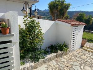 a white fence with a garden in front of a house at CASA FLORIS in Tertenìa