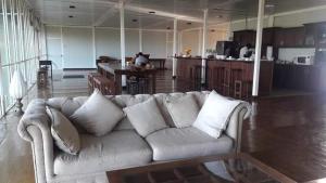 a living room with a couch and a kitchen at Kitty cointainer bungalow ambewela - kcb ambewela in Nuwara Eliya